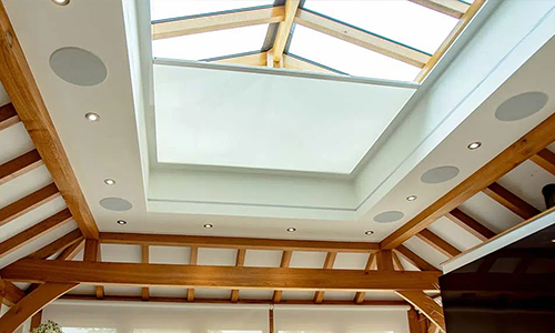 Motorised roof lantern blinds in a house with wooden interior